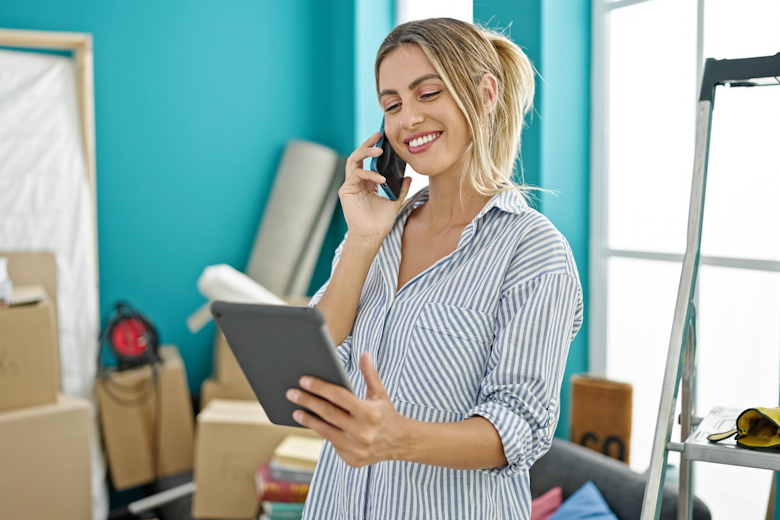 Vrouwelijke ondernemer aan de telefoon tijdens het verhuizen