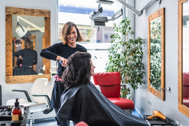 kapster brengt het haar van een klant in model